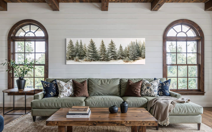 Panoramic canvas wall art featuring a row of sage green pine trees above a modern living room sofa.