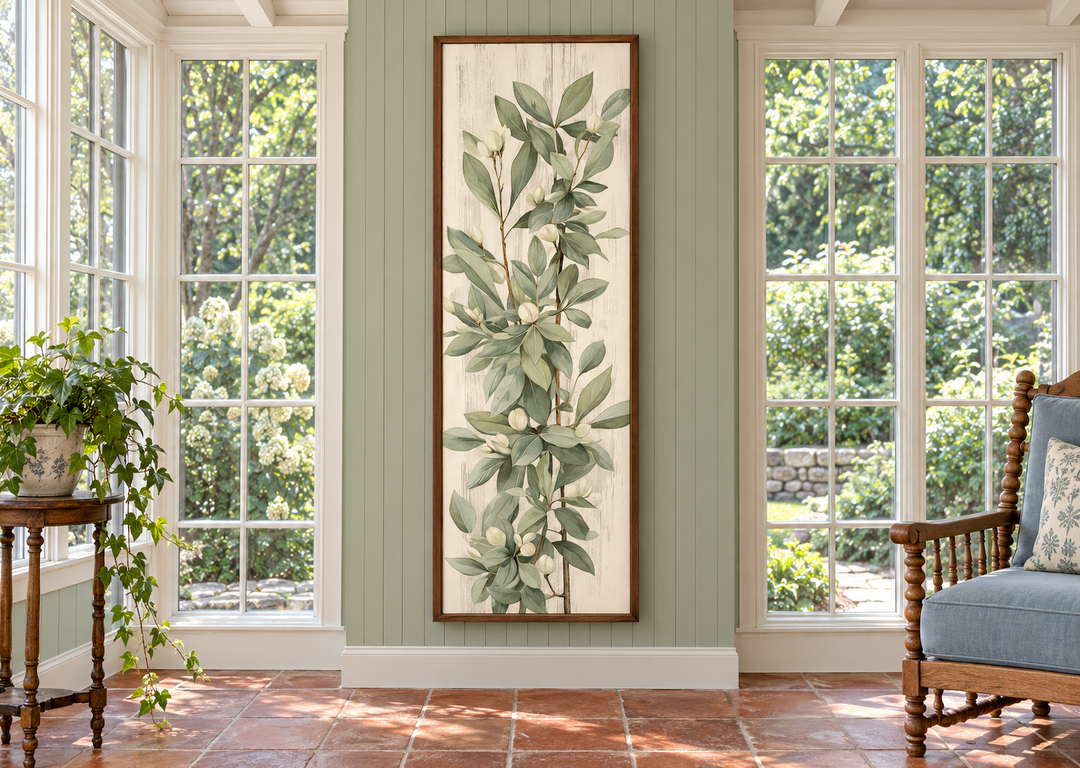 Tall slim vertical vintage sage green leaves framed canvas wall art in a sunroom setting.