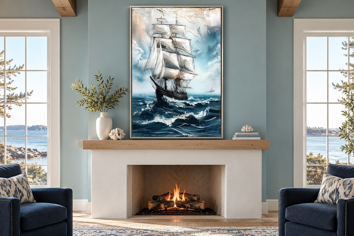 Abstract sailing ship wall art in a silver frame hanging above a white fireplace in a coastal room.