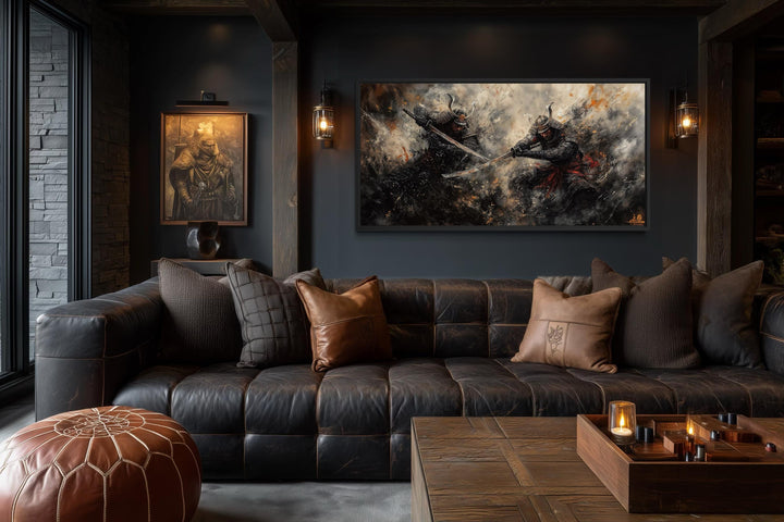 A wide canvas of a dramatic samurai duel in dark tones hangs above a leather sofa in a moody room.