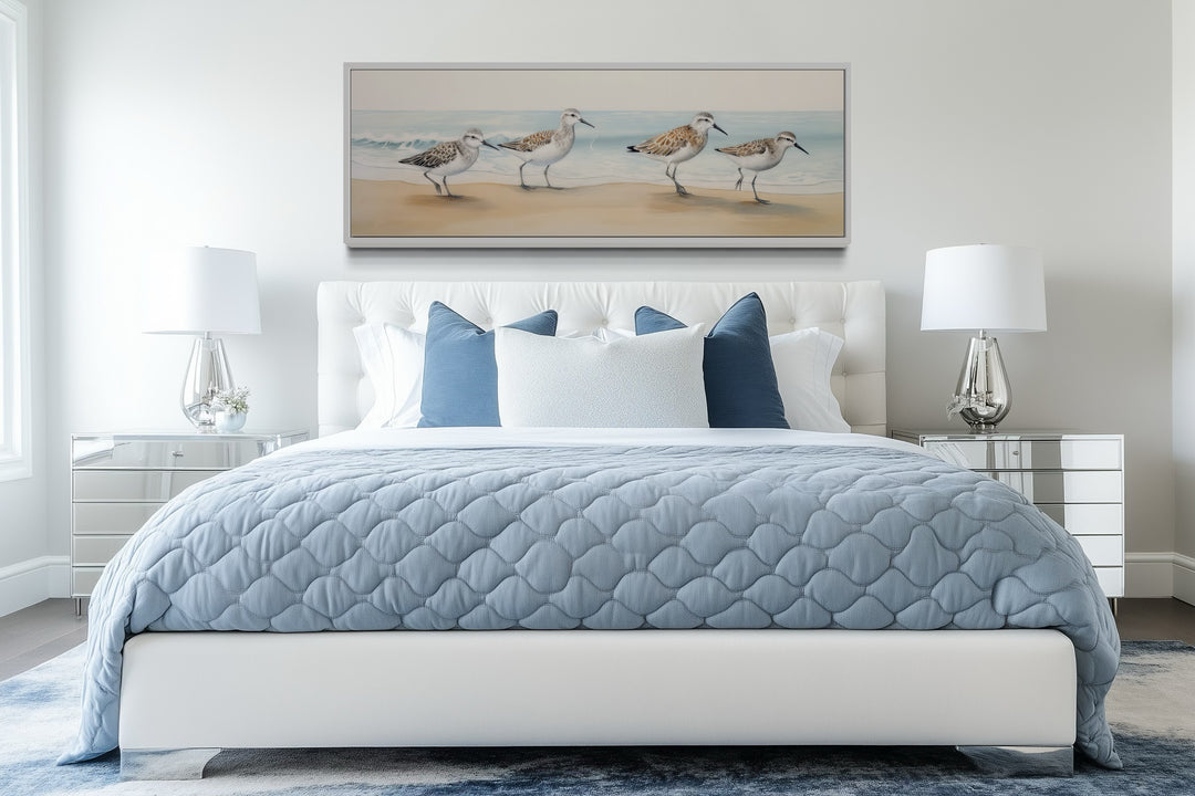 Framed canvas art of sandpipers walking on a beach.