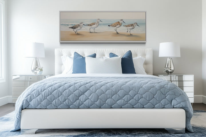 Framed canvas art of sandpipers walking on a beach.