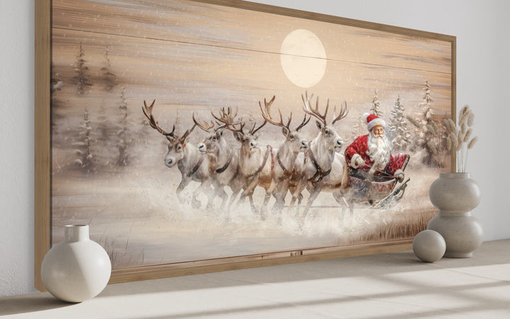 Rustic Santa Claus in a sleigh with reindeer wall art on a wood-textured canvas in a modern room.