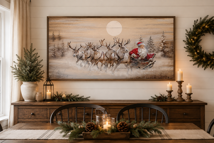 Rustic Santa Claus in sleigh with reindeer wall art above a wooden sideboard with holiday decor.