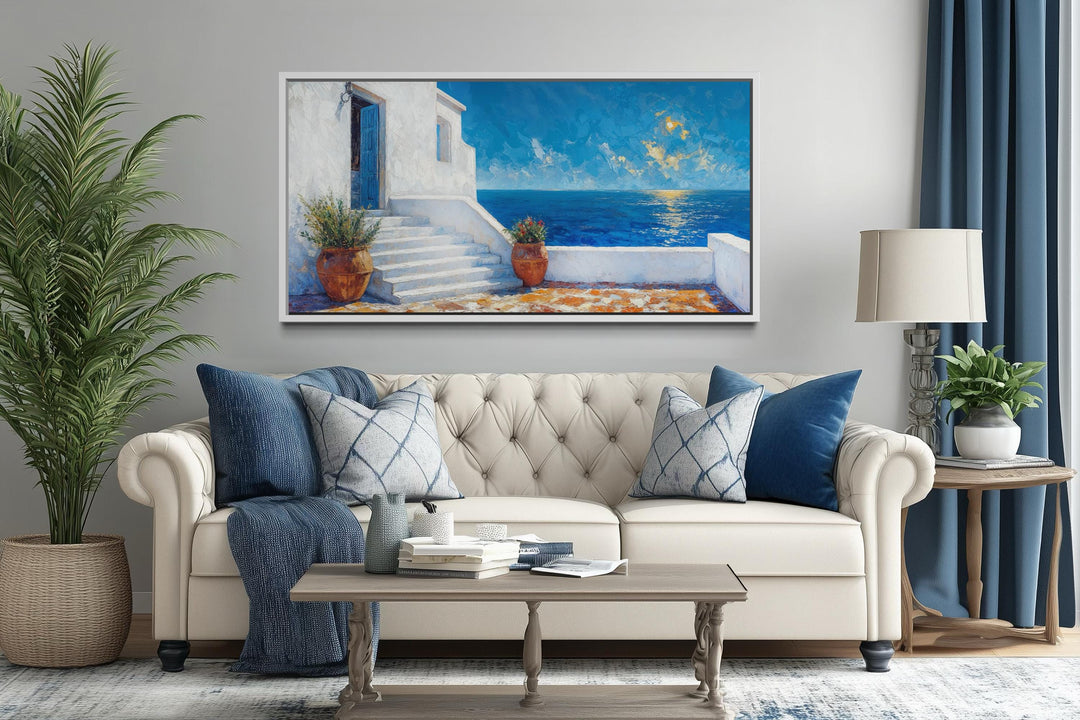 Santorini coastal villa wall art featuring a blue door and ocean view above a white sofa.