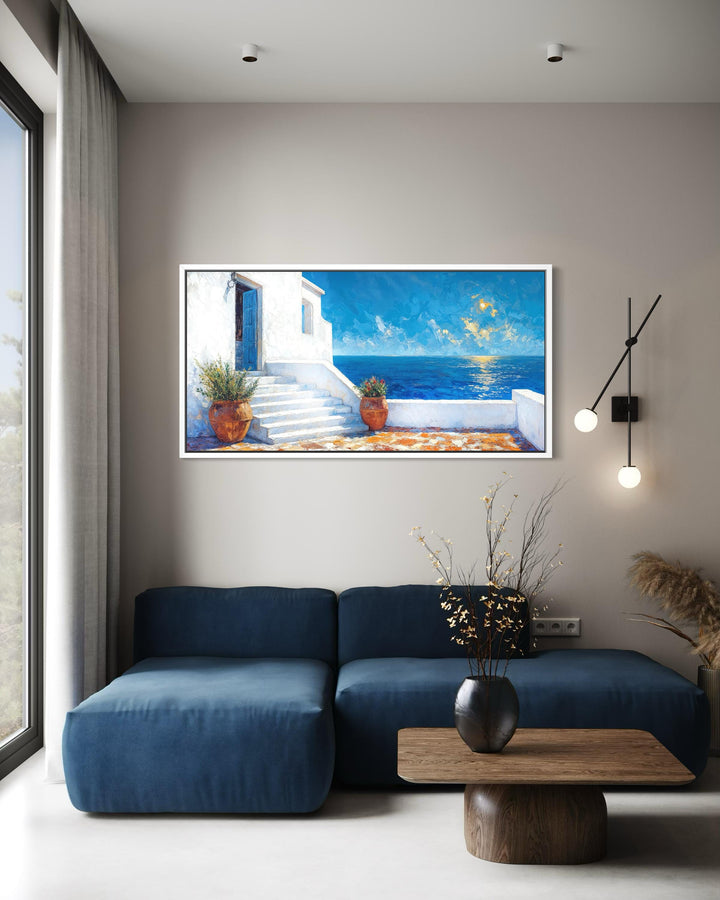 A horizontal Santorini coastal villa canvas painting with vibrant blue ocean views in a modern room.
