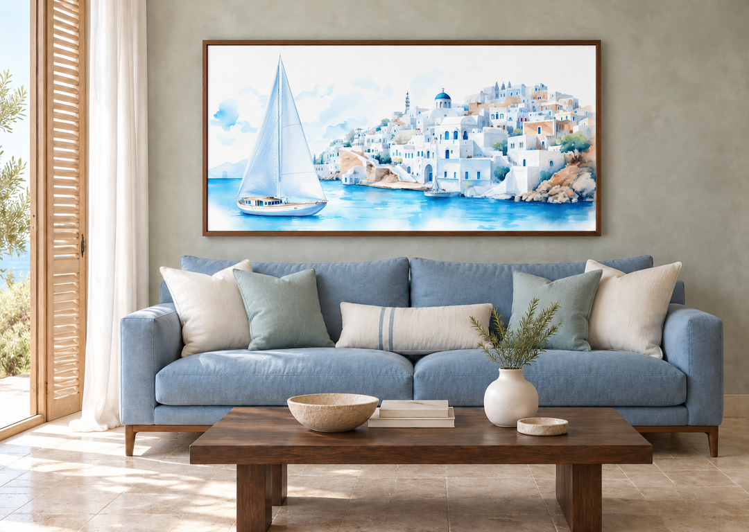 Santorini Sea and Sailboat Framed Canvas Wall Art above a blue sofa in a coastal living room.
