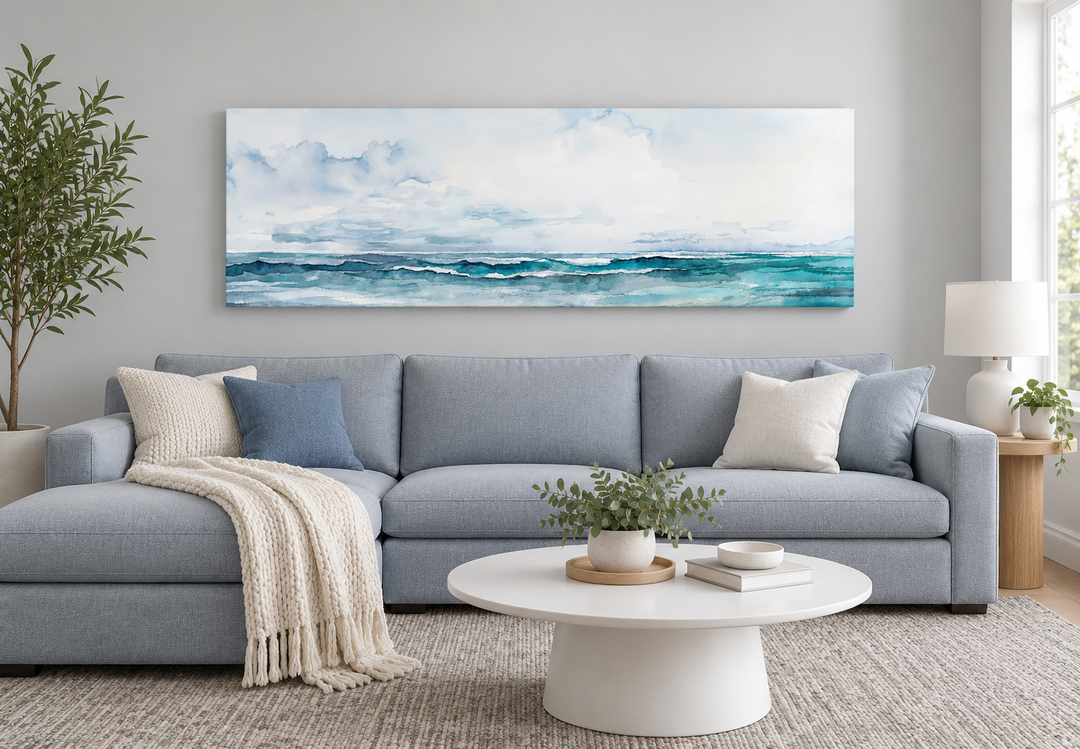 Minimalist ocean blue and gray horizontal canvas wall art hanging above a light blue sectional sofa.