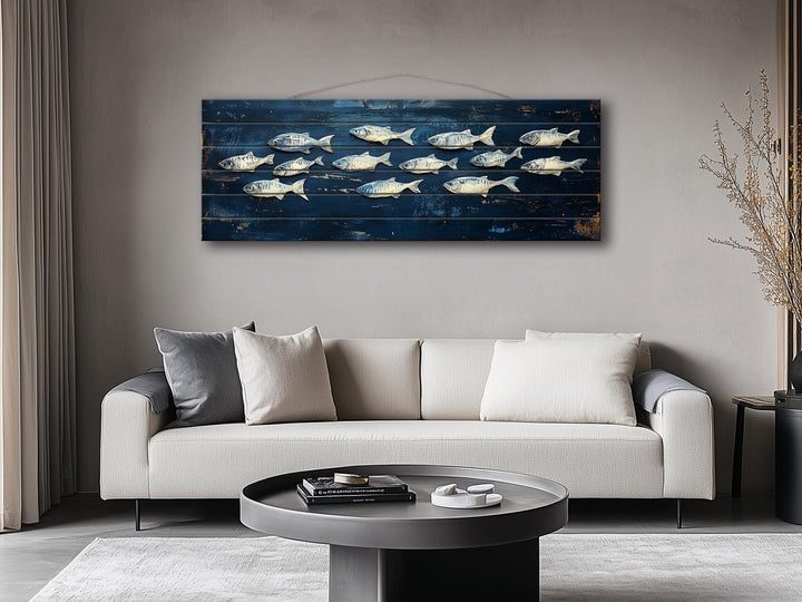 Long narrow distressed wood wall art featuring a school of fish on a deep blue background.