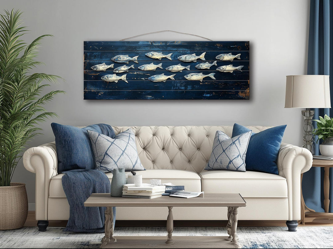 Long narrow distressed wood wall art featuring a school of fish on a deep blue background.