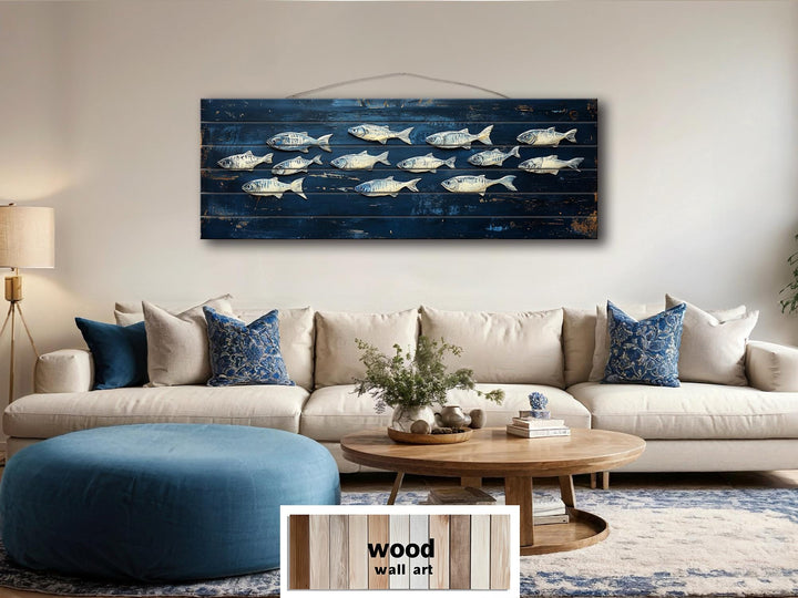 A long, narrow distressed wood wall art piece featuring a school of fish on a deep blue background.