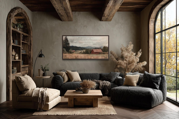 A framed landscape painting with a red barn and Numbers 6:24-26 scripture hangs in a rustic room.