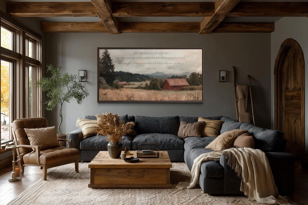 Scripture wall art with Numbers 6:24-26 over a landscape with a red barn in a rustic living room.