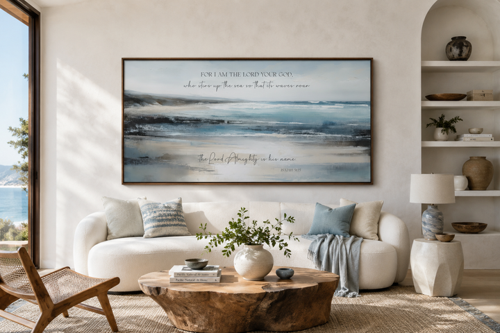 Coastal canvas wall art with Isaiah 51:15 scripture above a white sofa in a bright living room.