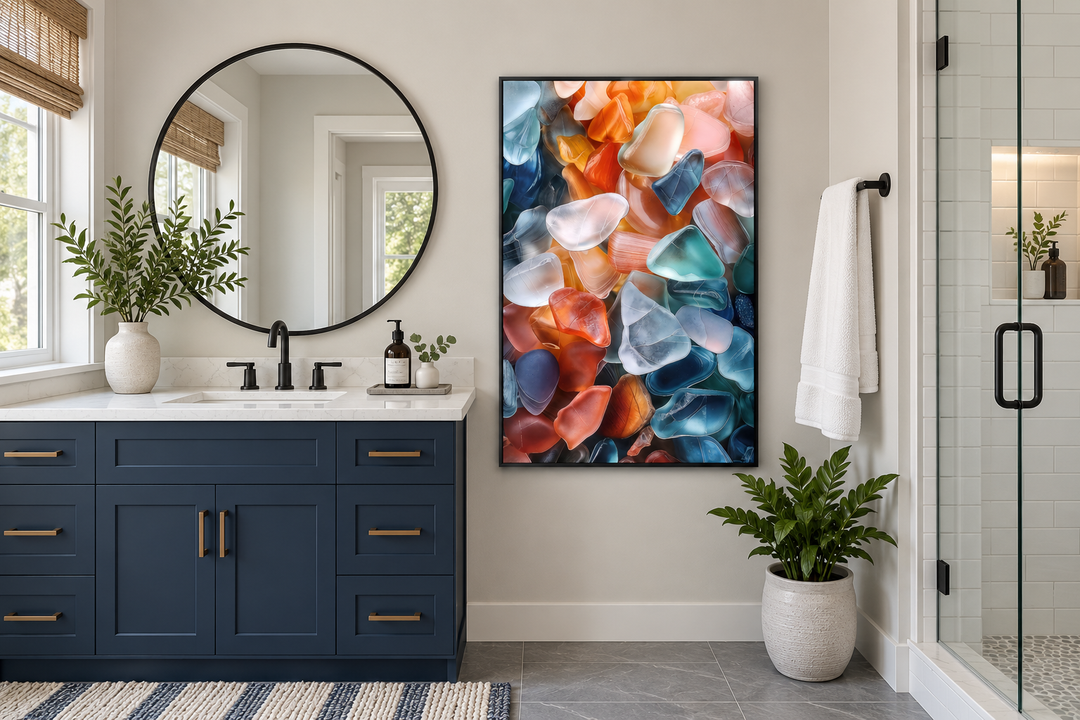 Vertical sea glass wall art in a black frame above a navy blue bathroom vanity.