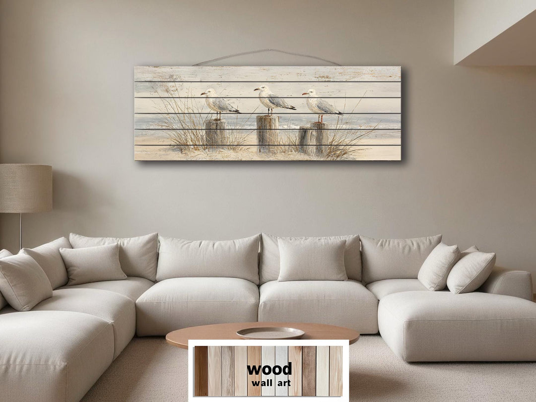 Large horizontal wood wall art featuring seagulls on beach posts above a modern sectional sofa.