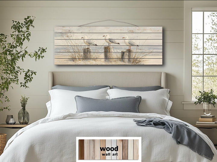 Large horizontal wood wall art featuring three seagulls perched on beach posts in a coastal scene.
