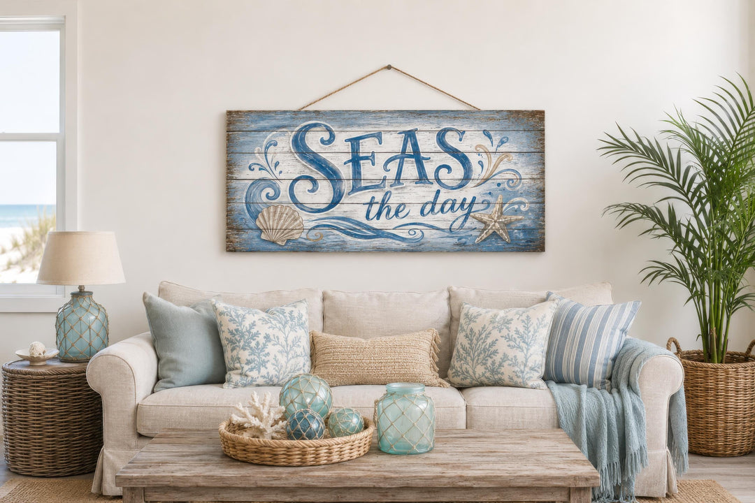 Seas The Day distressed wood wall art hanging above a coastal-themed sofa with nautical accents.