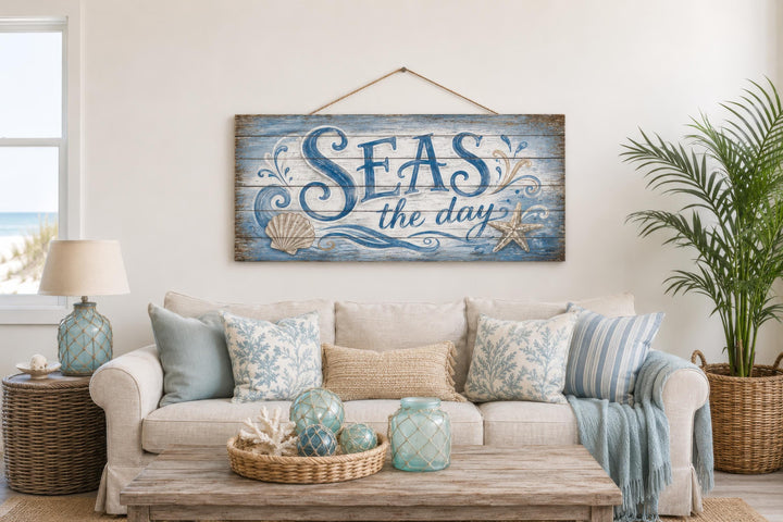 Seas The Day distressed wood wall art hanging above a coastal-themed sofa with nautical accents.