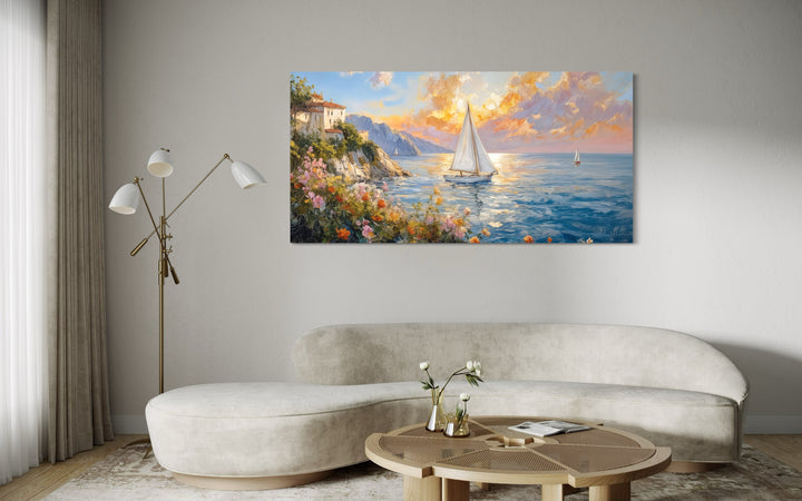 Modern coastal framed canvas print of a sunset seascape with sailboats above a curved sofa.