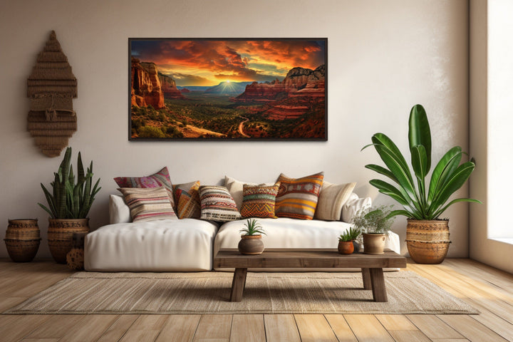 Framed Sedona sunset canvas art above a white sofa with colorful pillows in a rustic living room.