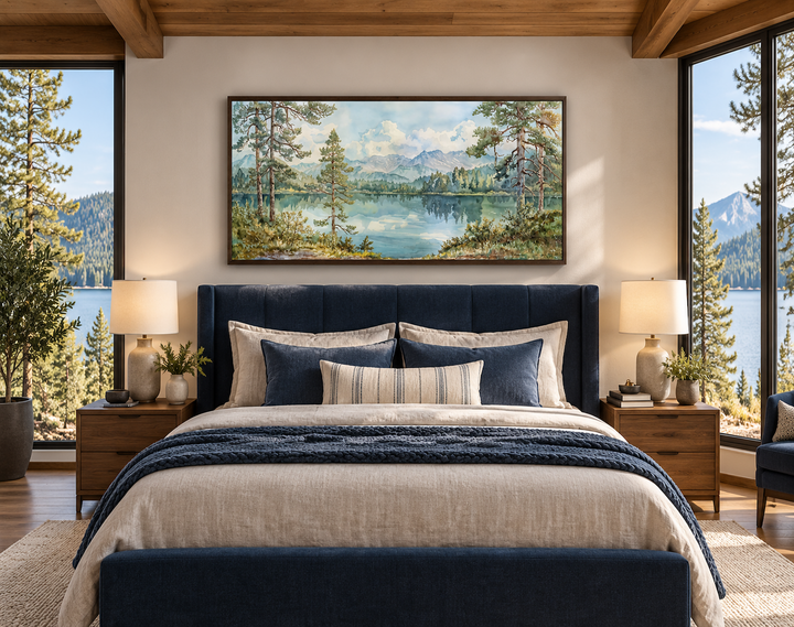 Framed panoramic mountain lake landscape canvas art above a blue bed in a rustic bedroom.