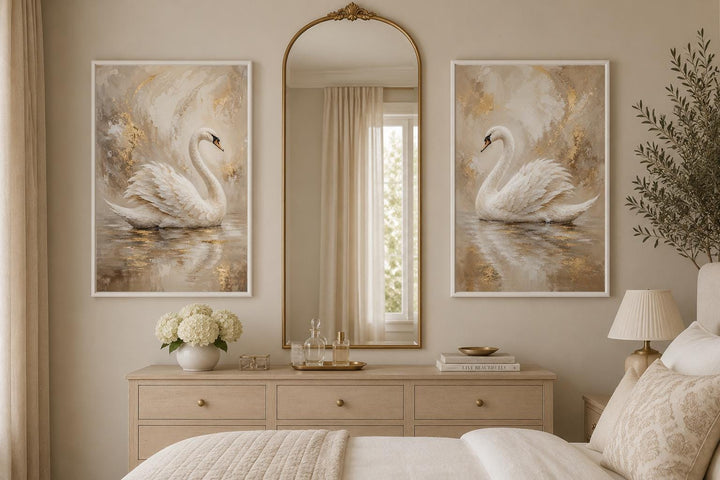 Set of 2 white swan canvas art prints with gold accents in a glam bedroom above a dresser.