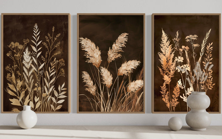 Set of 3 brown and beige boho canvas wall art featuring botanical grass on earthy backgrounds.
