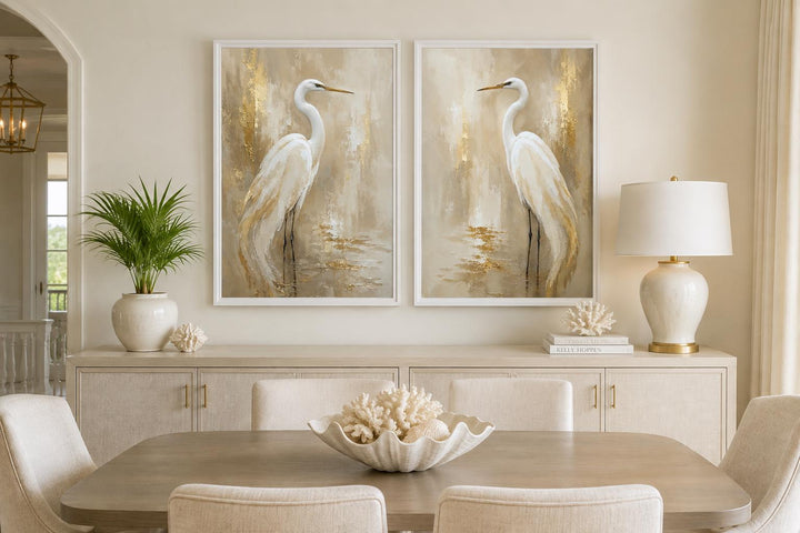 Set of 2 white egret canvas wall art prints with gold accents above a dining room sideboard.