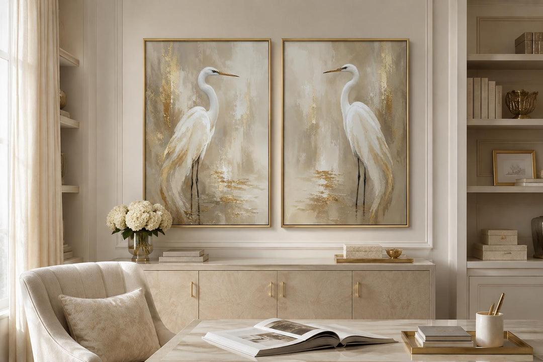 Set of 2 white egret canvas wall art pieces with golden water accents in gold frames.