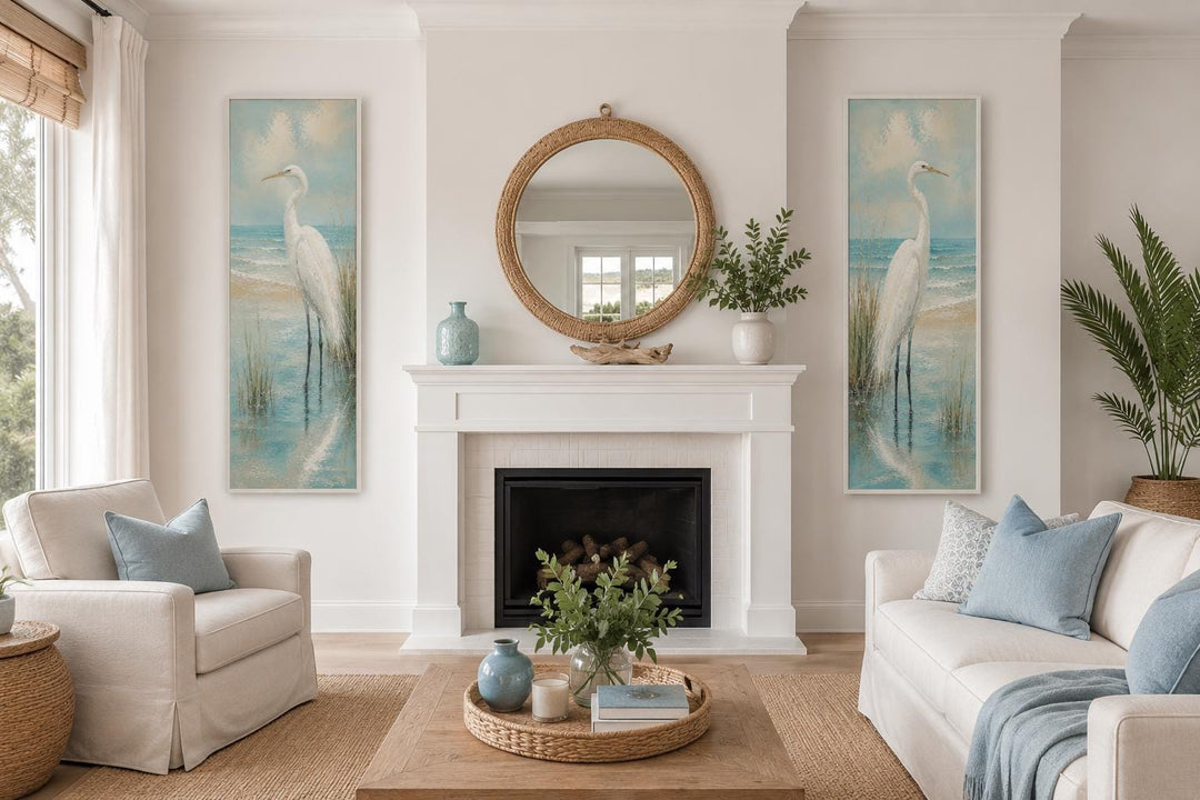 Set of 2 tall narrow coastal egret canvas prints flanking a fireplace in a bright living room.