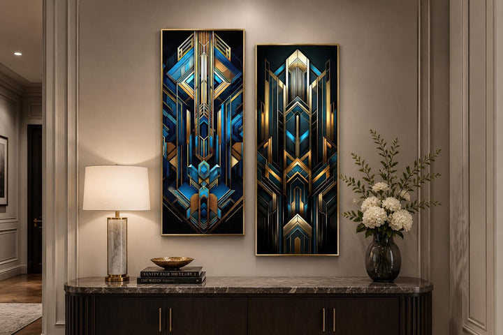 Set of 2 tall vertical Art Deco geometric canvas panels in navy blue and gold on a console table.