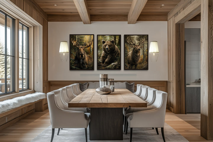 Set of 3 framed canvas paintings featuring a moose, bear, and elk in a rustic dining room.