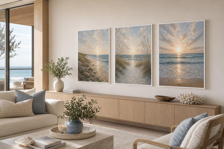 Set of 3 beach sunset canvas prints with dunes and waves in a coastal living room.