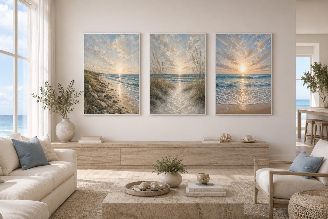 Set of 3 beach sunset canvas prints with dunes and waves in a coastal living room.