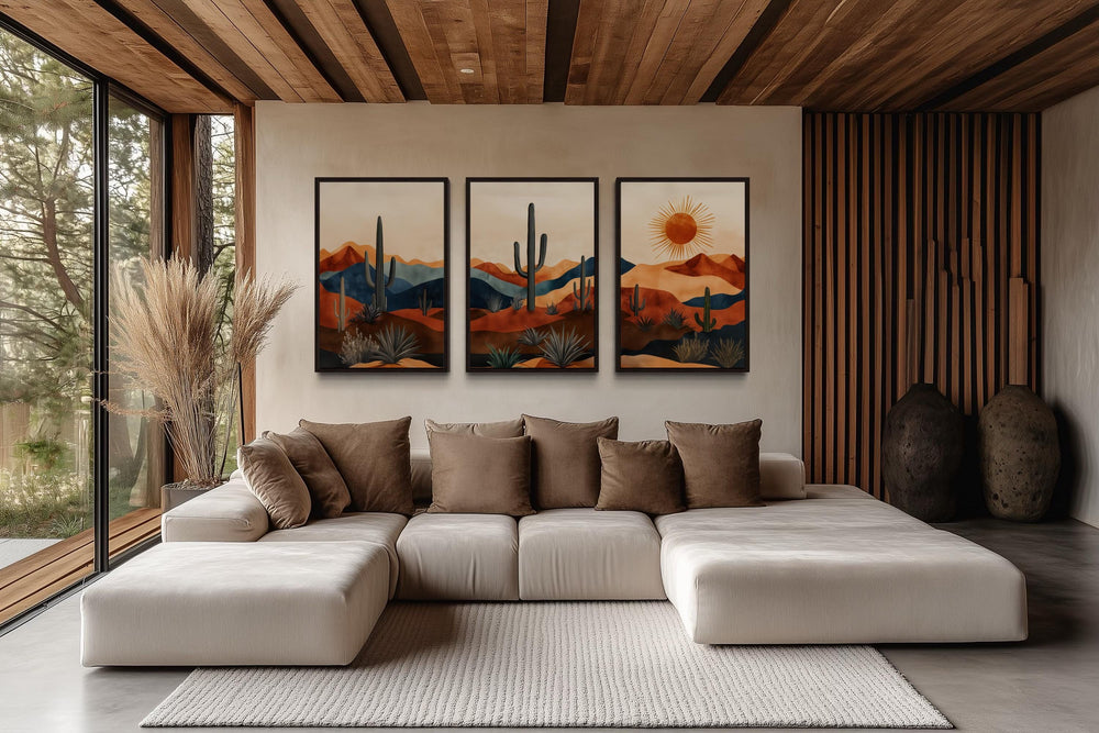 Set of 3 mid-century modern desert wall art prints with saguaro cacti and sun over a sofa.