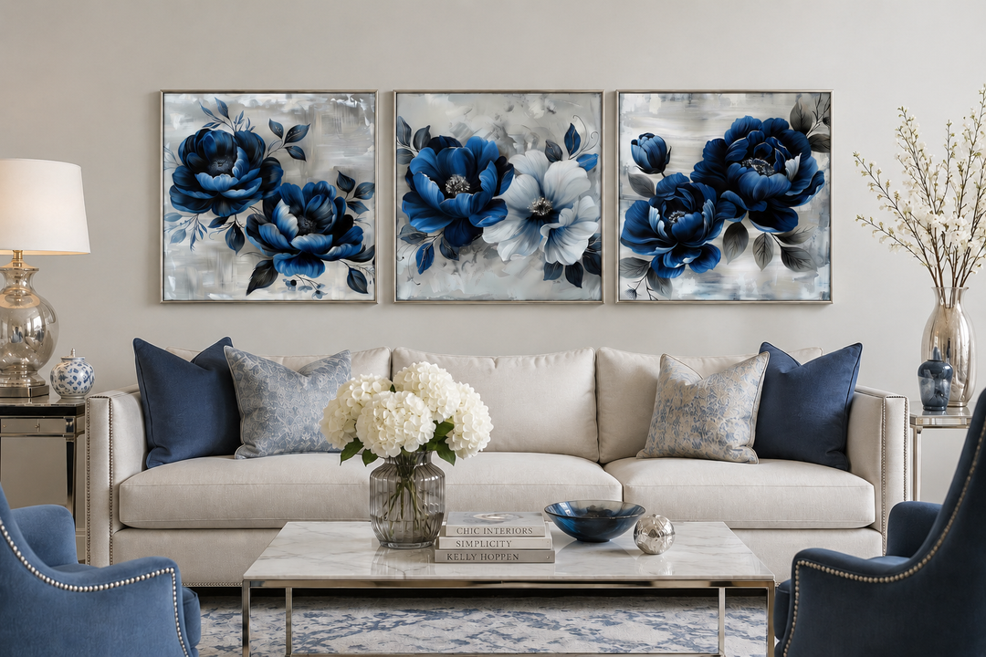 Set of 3 navy blue and gray floral square canvas prints hung above a sofa in a modern living room.
