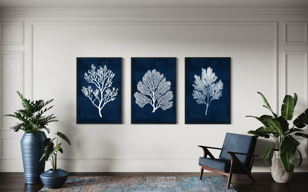 Set of three vertical navy and white sea coral canvas wall art panels in a modern living room.