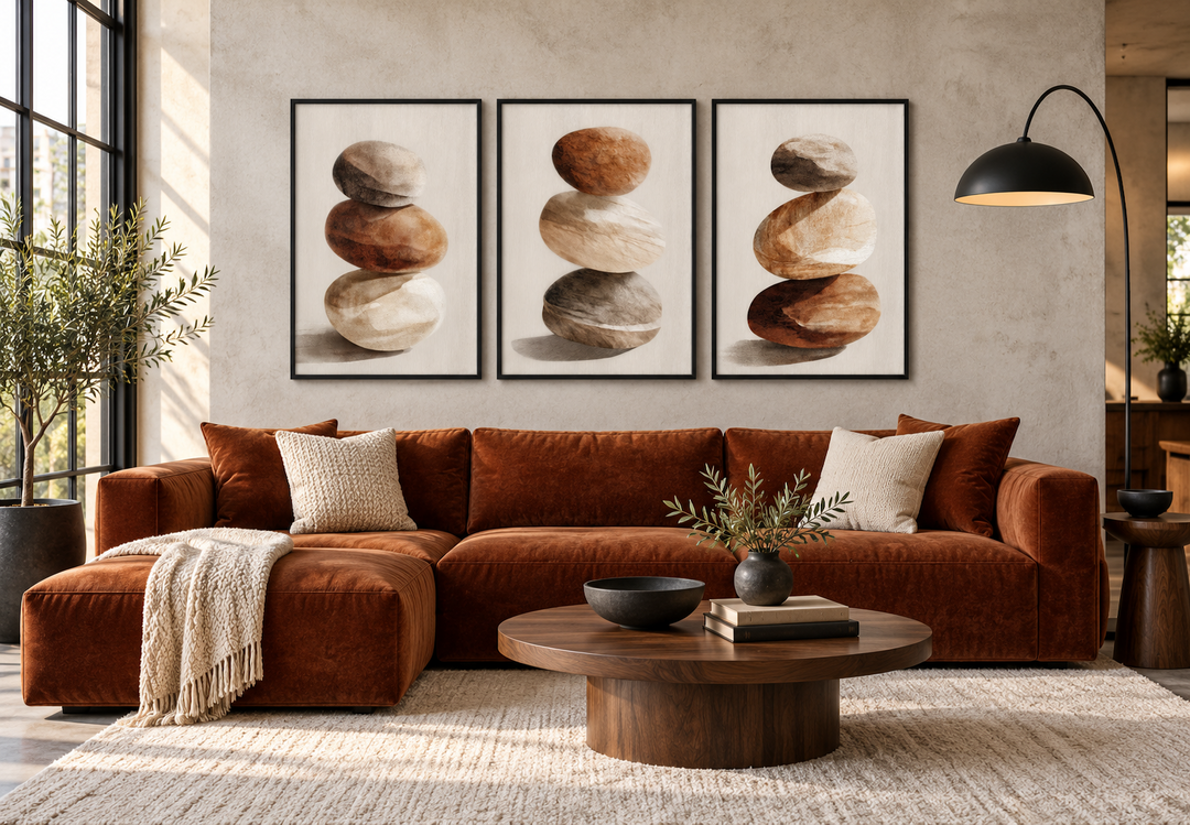 Set of 3 minimalist wall art prints featuring stacked stones in neutral earth tones above a sofa.