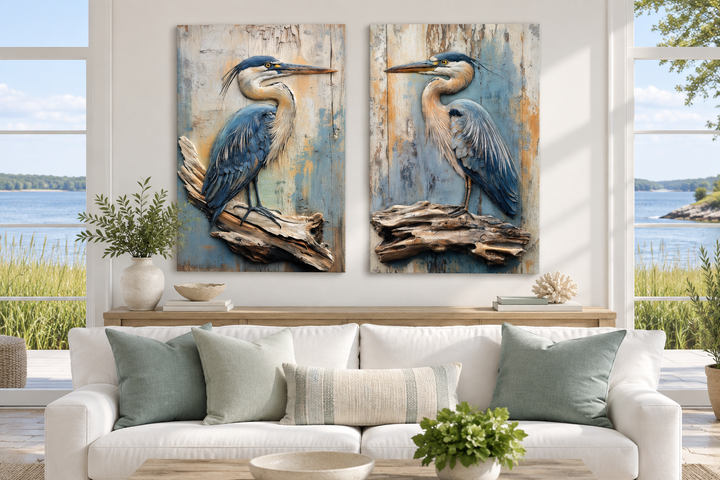 Set of 2 rustic blue herons on driftwood framed canvas wall art above a white sofa.