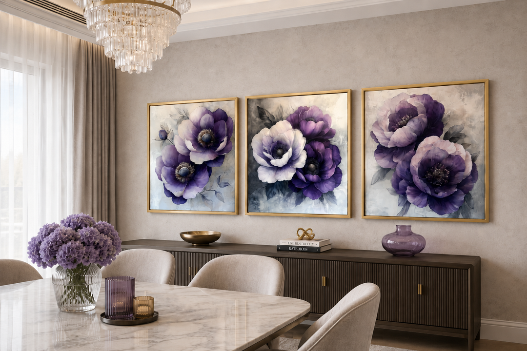 Set of three purple floral canvas prints with gold frames above a dark wood sideboard.