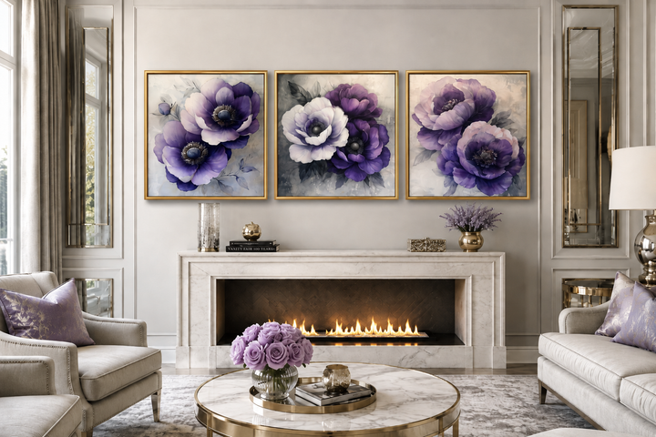 Set of three framed purple floral canvas prints displayed above a marble fireplace in a living room.