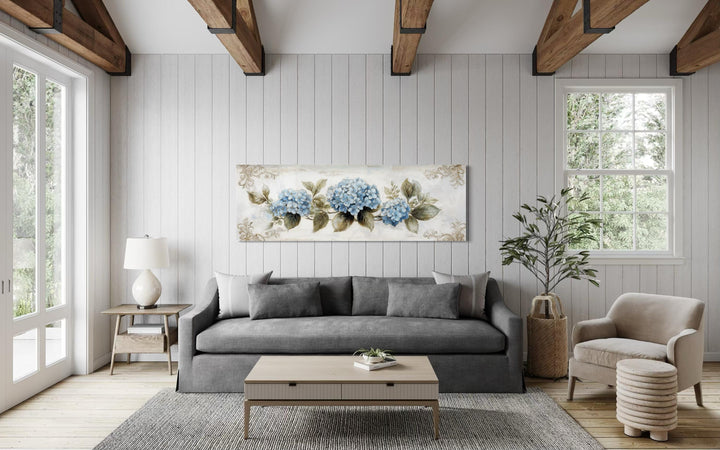 Shabby chic long horizontal canvas wall art featuring blue hydrangea blooms on a neutral wall.