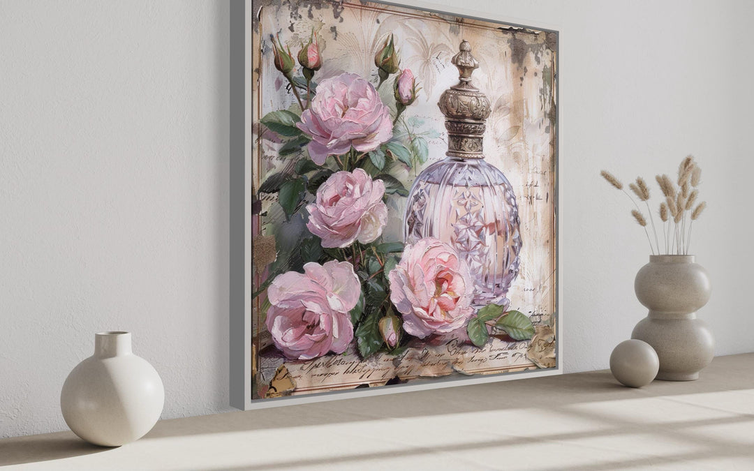 Shabby chic framed canvas wall art featuring a vintage pink perfume bottle and roses.