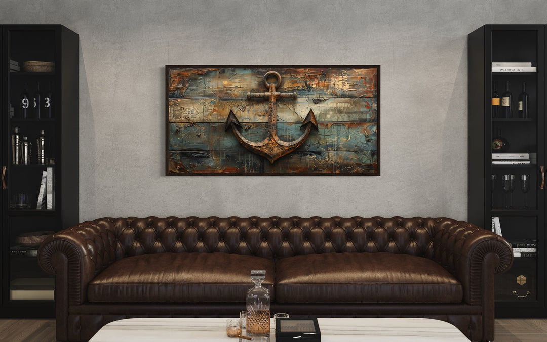 Nautical framed canvas wall art featuring a ship's anchor painted on weathered wood above a sofa.