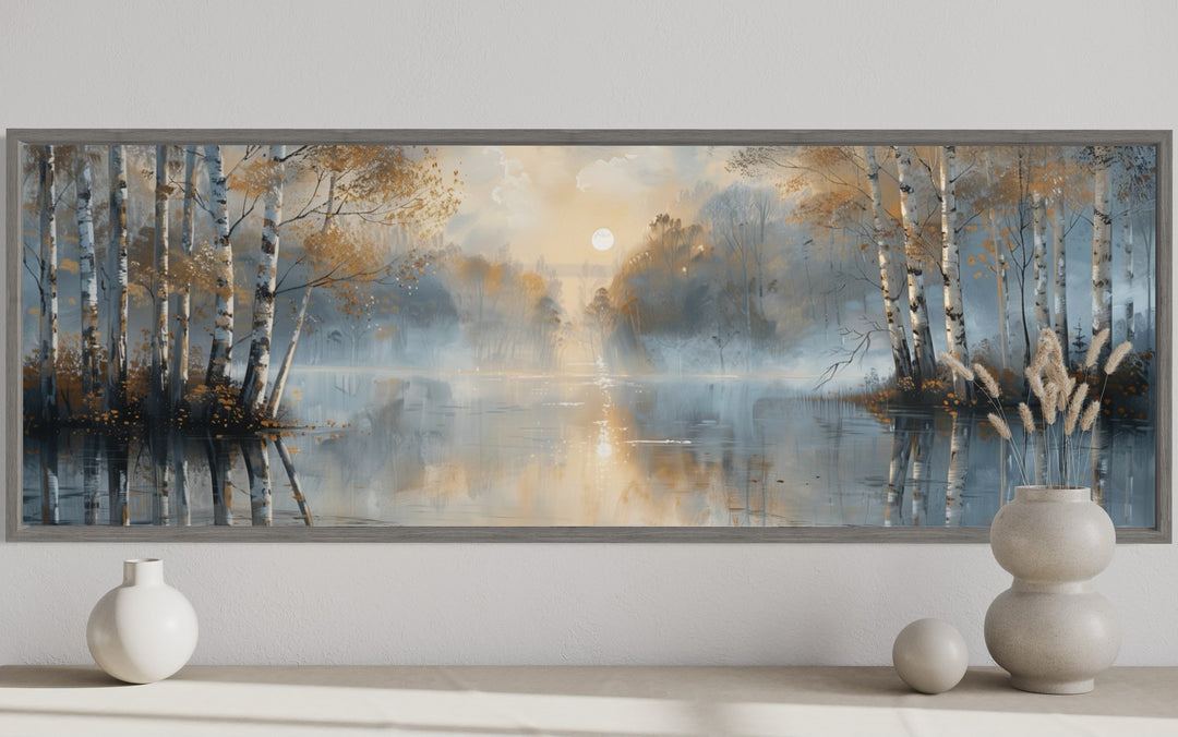 Silver birch trees forest wall art in a long horizontal frame above a console with decorative vases.