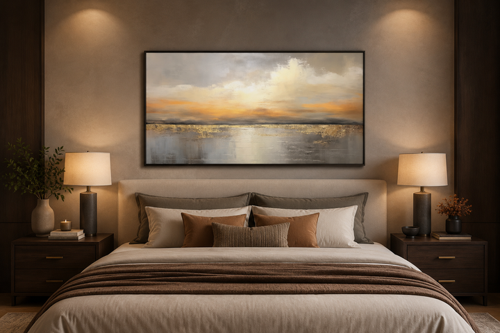 Silver and gold abstract ocean sunset framed canvas wall art hanging above a bed in a bedroom.