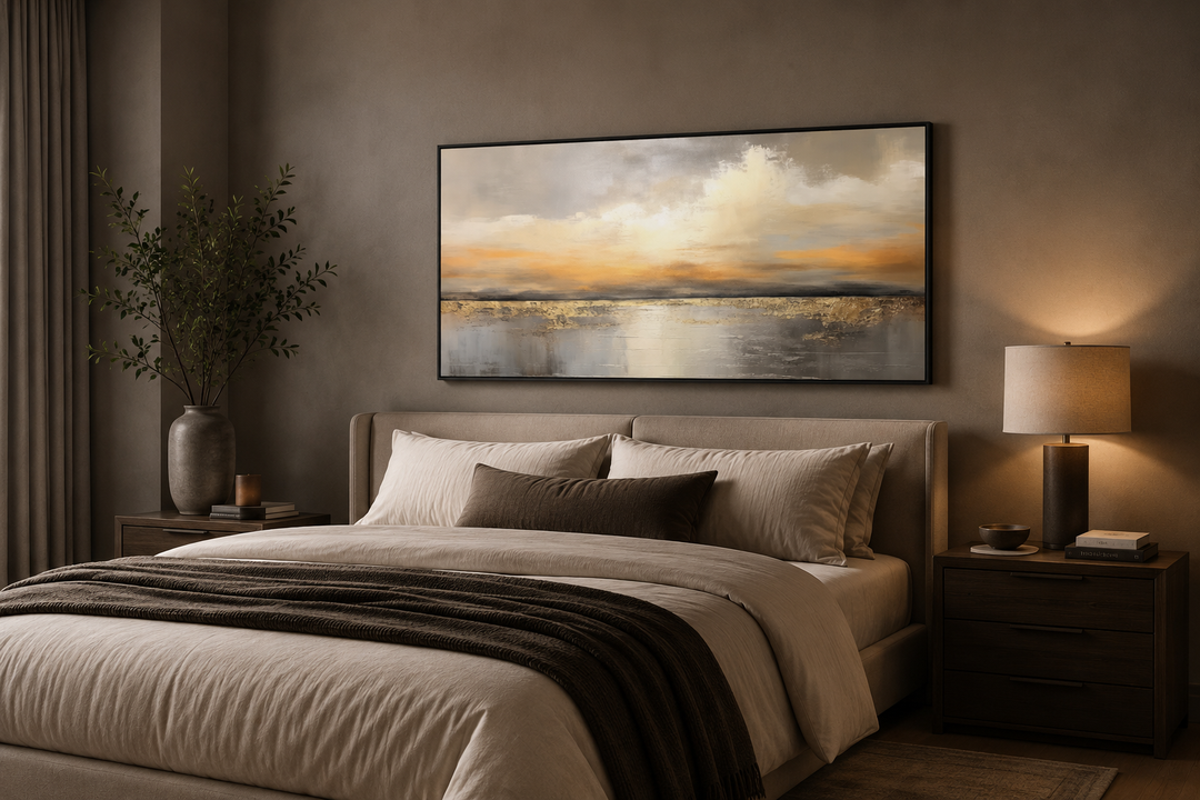 Silver and gold abstract ocean sunset framed canvas wall art hanging above a bed in a bedroom.