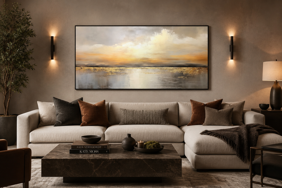 Silver and gold abstract ocean sunset framed canvas wall art hanging above a modern beige sofa.