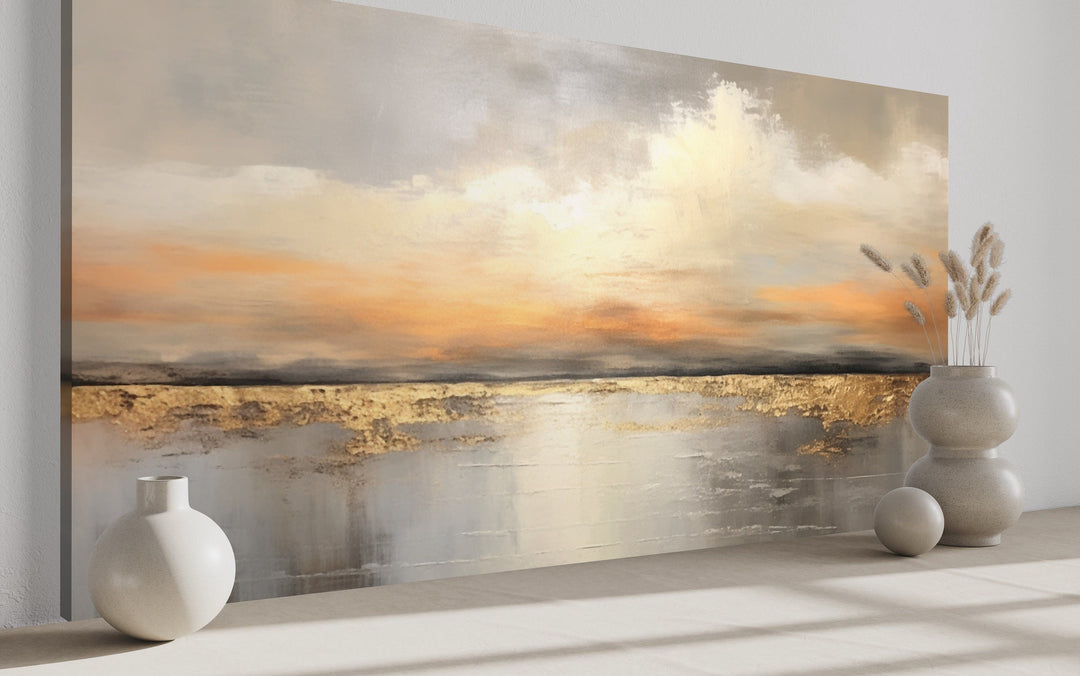 Silver and gold abstract ocean sunset framed canvas wall art in a modern living room setting.